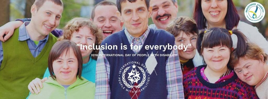 Ten people with disabilities in a group photo, smiling and wearing sweaters. "Inclusion is for everybody" is written above the IDPWD logo.